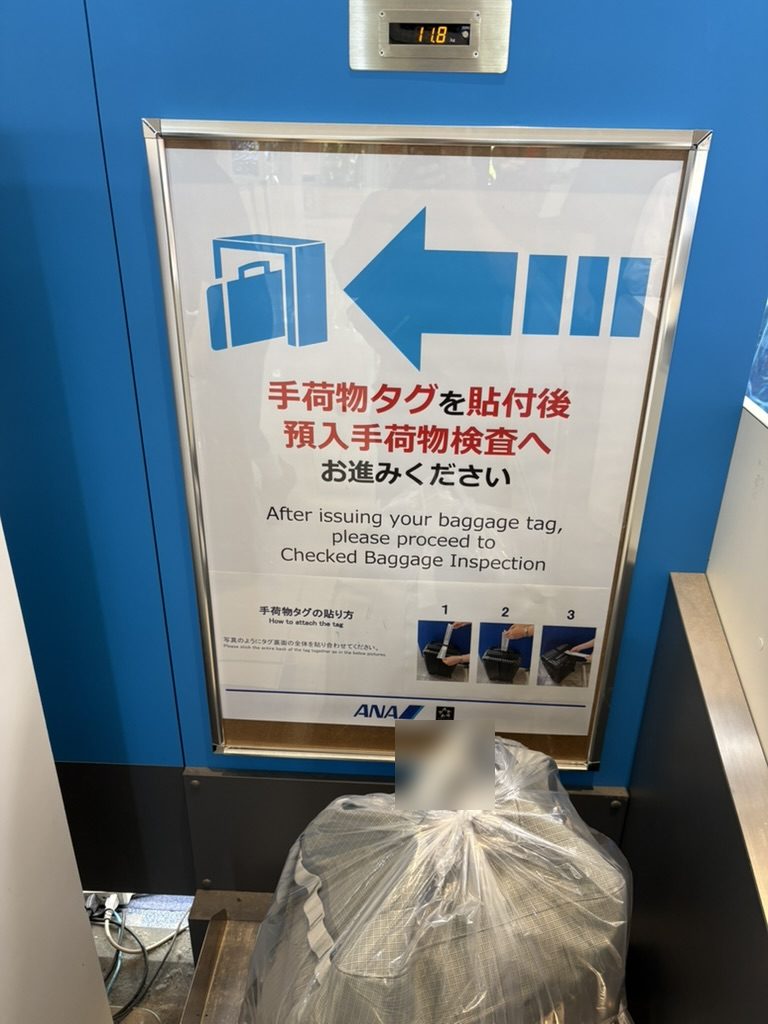 ANAの手荷物カウンターで荷物の重さを量っているところ(写真は25kgだった荷物とは別の荷物。表示は11.8kg)